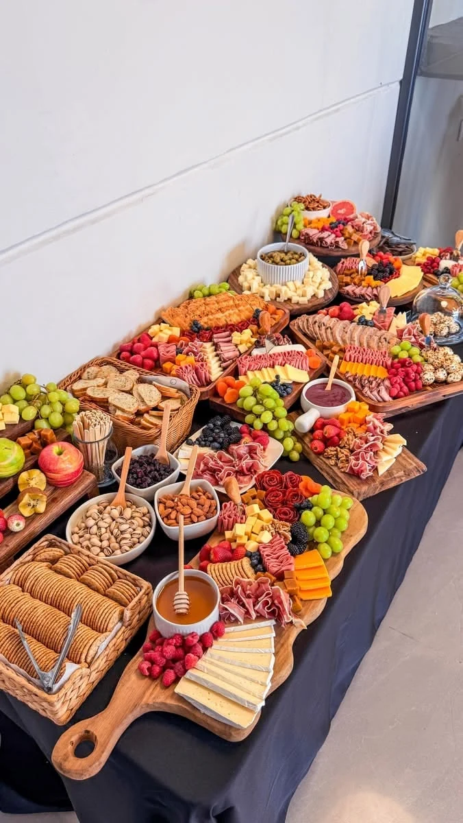 A curated indoor grazing station with cheeses, charcuterie, fruit, and accompaniments