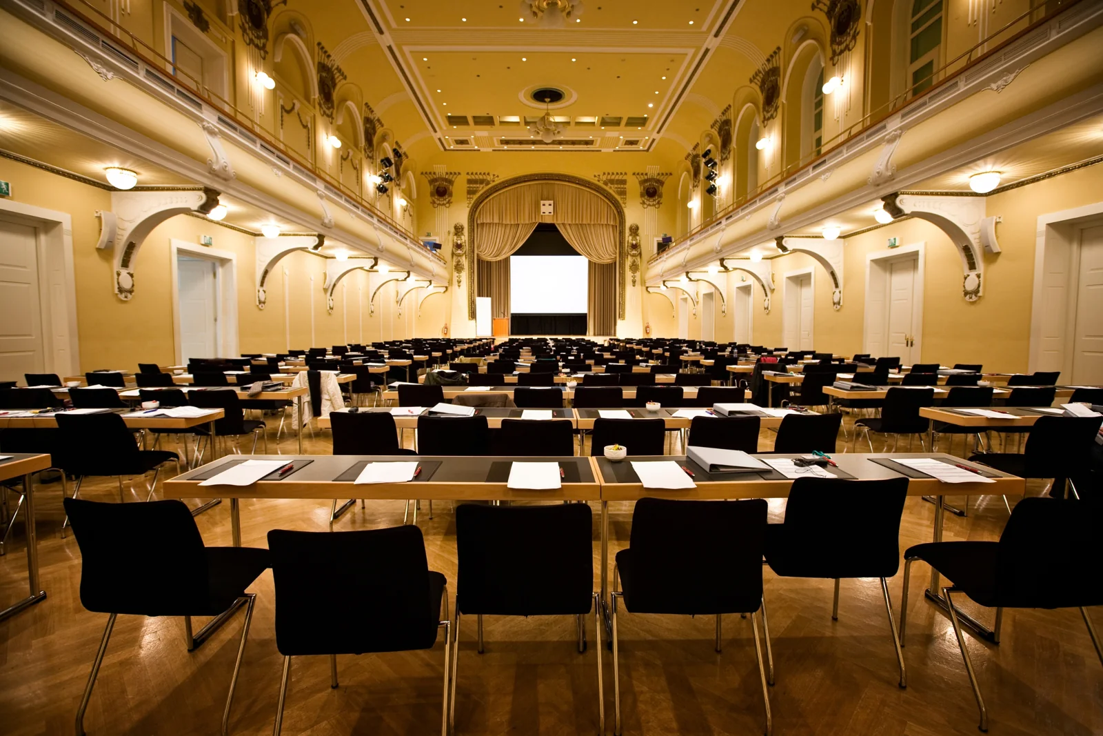 A conference room prepared with tables, chairs, and a presentation area