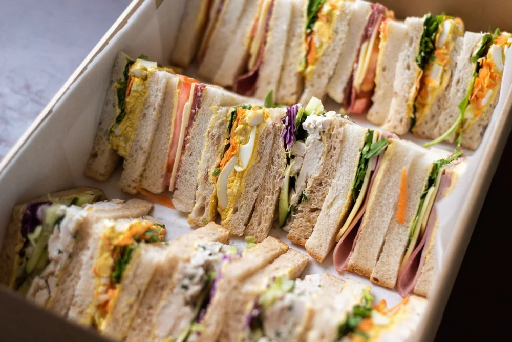 A selection of fresh sandwich triangles prepared for catered delivery