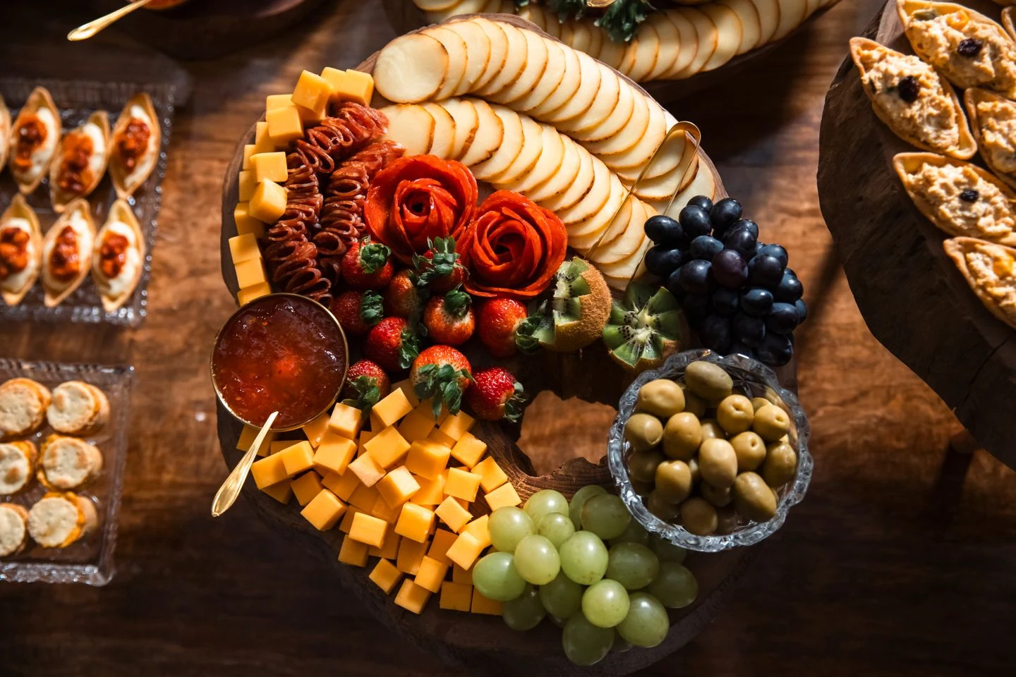 Artfully arranged charcuterie with cured-meat roses, cheeses, crackers, grapes, and accompaniments