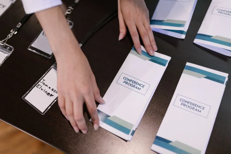 Conference materials being organized at an event registration table