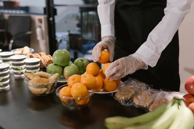 A hospitality worker carefully arranging food for service